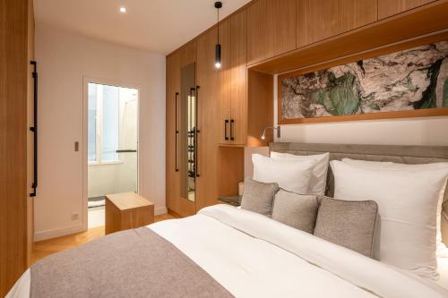 une chambre avec un grand lit blanc et des murs en bois dans l'établissement SaintGermainByCecile - Luxueux 2 pièces AC Jade, à Paris