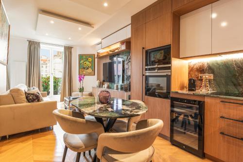une cuisine et un salon avec une table et des chaises dans l'établissement SaintGermainByCecile - Luxueux 2 pièces AC Jade, à Paris