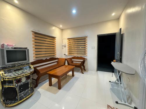 a living room with a flat screen tv and a couch at Sariaya Quezon Transient in Sariaya