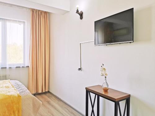 a bedroom with a bed and a television on the wall at Appartments " Zhetysu-4" in Almaty