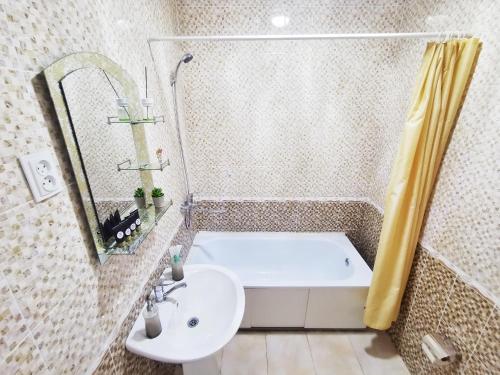 a bathroom with a bath tub and a sink at Appartments " Zhetysu-4" in Almaty