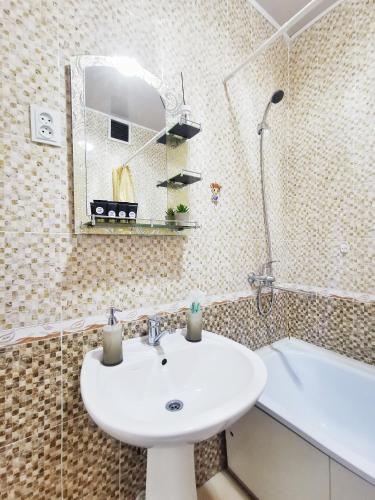a bathroom with a sink and a bath tub at Appartments " Zhetysu-4" in Almaty