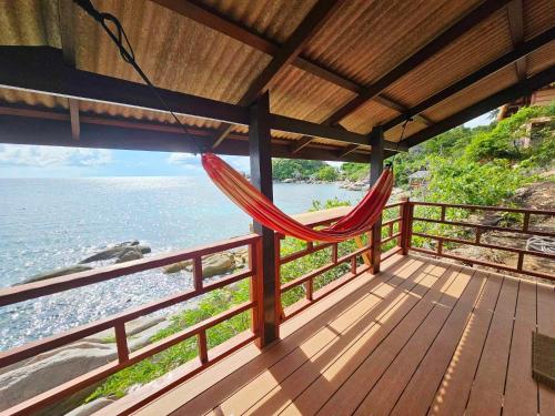 a hammock hanging on a balcony overlooking the ocean at Tao Thong Villa 2 in Ko Tao