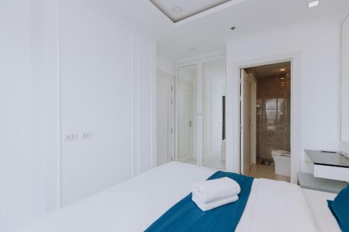 a white bedroom with a bed and a bathroom at The Empire Tower k in Jomtien Beach