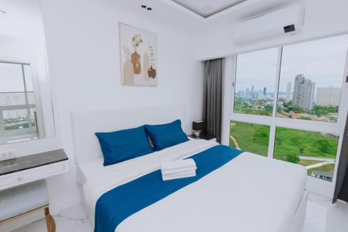 a white bedroom with a bed and a window at The Empire Tower k in Jomtien Beach