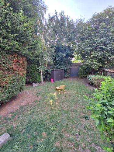 une cour avec un banc dans l'herbe dans l'établissement La villa Duchesse proche de Malo les Bains, à Dunkerque