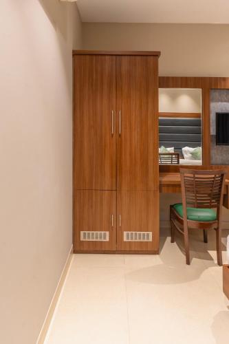 a kitchen with wooden cabinets and a table and a chair at Hotel Amritsar International 2 min walk from Amritsar Bus Stand in Amritsar