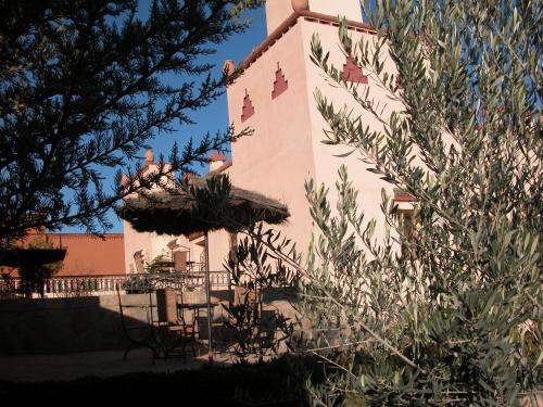 a building with a table and chairs in front of it at Kasbah Petit Nomade in Tinerhir
