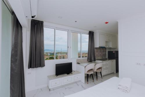 a kitchen with a table and a tv in a room at The Empire Tower k in Jomtien Beach