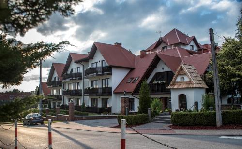 a large white building with a red roof at Pensjonat EDEN Maniowy in Maniowy