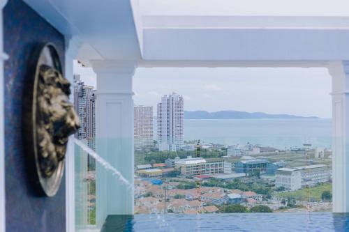 a clock on the side of a building with a city at The Empire Tower k in Jomtien Beach