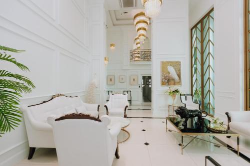 a living room with white furniture and a chandelier at The Empire Tower k in Jomtien Beach