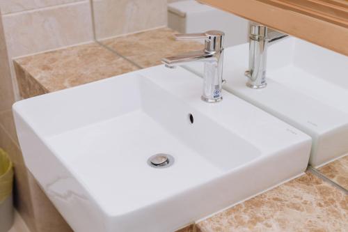 a white sink in a bathroom at The Empire Tower k in Jomtien Beach