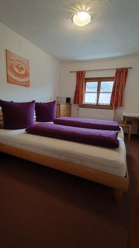 a bedroom with two beds with purple pillows at Haus Lädeler in Schruns