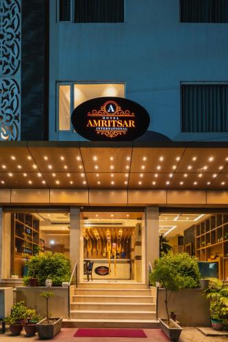 a building with a sign on the front of it at Hotel Amritsar International 2 min walk from Amritsar Bus Stand in Amritsar