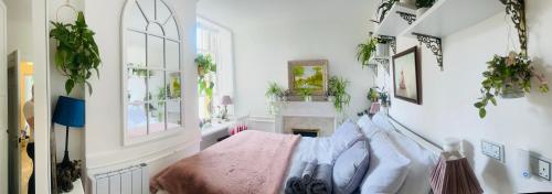 a bedroom with a bed with a pink blanket at Flat in the heart of Bath with stunning views in Bath