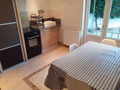 - une cuisine avec une table, une cuisinière, une table et des chaises dans l'établissement Appartement Agen centre, à Agen