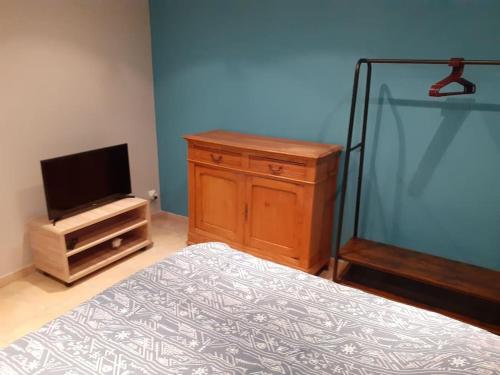 une chambre avec un lit et une commode avec une télévision dans l'établissement Appartement Agen centre, à Agen