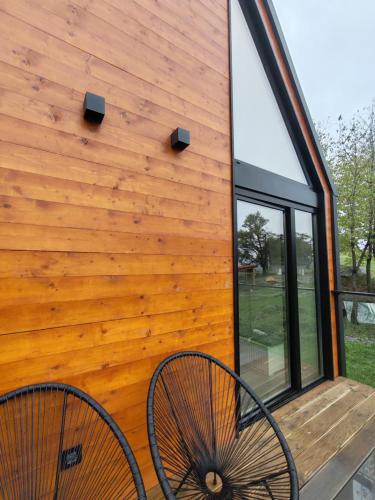 a wooden cabin with two chairs sitting on a deck at Porta Bungalows in Rudnik Kačerski