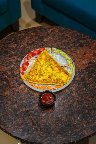 a slice of pizza on a plate on a table at Hotel Amritsar International 2 min walk from Amritsar Bus Stand in Amritsar