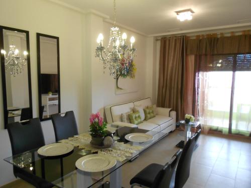 een woonkamer met een tafel en een bank bij Jardinas de les Marinas in Denia