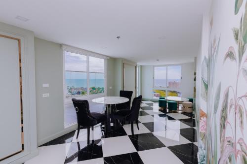 a room with a table and chairs and windows at The Empire Tower k in Jomtien Beach