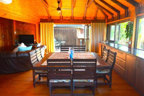 a dining room with a wooden table and chairs at Sodwana Bay Lodge House 34 in Sodwana Bay