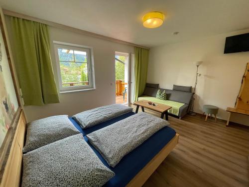 a bedroom with a bed and a couch and a window at B&B Simmer in Obertraun