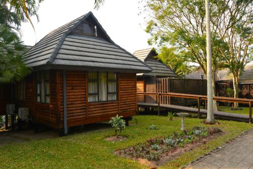a small wooden cabin with a gambrel roof at Sodwana Bay Lodge House 34 in Sodwana Bay