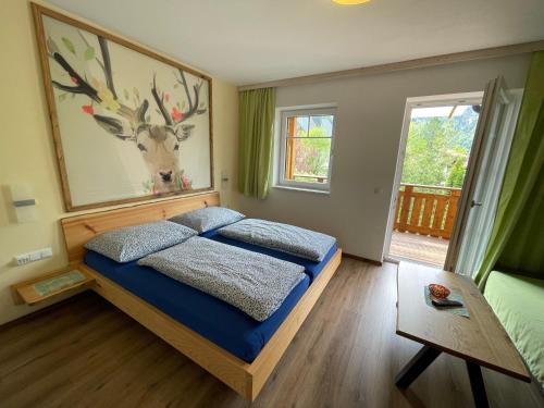 a bedroom with a bed with a deer picture on the wall at B&B Simmer in Obertraun