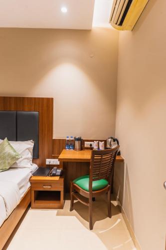 a bedroom with a desk and a bed and a chair at Hotel Amritsar International 2 min walk from Amritsar Bus Stand in Amritsar