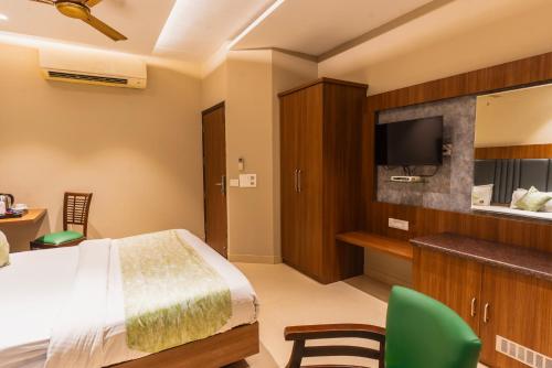 a bedroom with a bed and a flat screen tv at Hotel Amritsar International 2 min walk from Amritsar Bus Stand in Amritsar