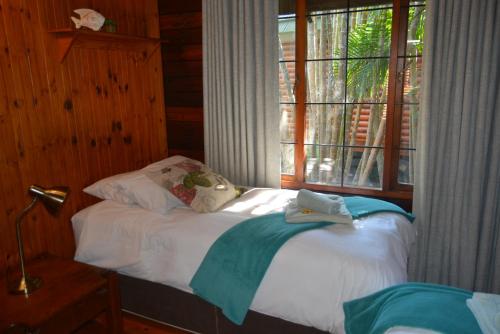 a bed with towels on it in a room with a window at Sodwana Bay Lodge House 34 in Sodwana Bay