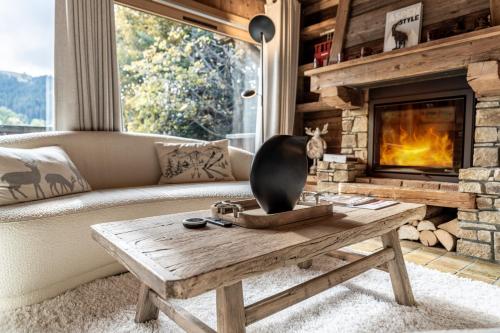 un salon avec un canapé et une cheminée dans l'établissement Chalet Mont d'Arbois Ski et Golf, à Megève