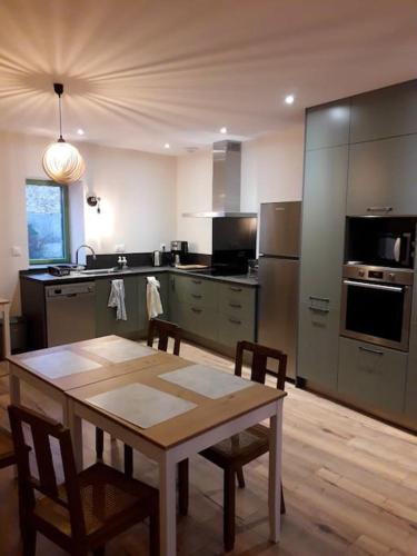 une cuisine avec une table et des chaises dans une pièce dans l'établissement Gite bien-être pour familles, amis, stages, pros, à Aubiat