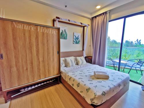 a bedroom with a bed with a large window at Timurbay Seafront Residences by Nature Home in Kuantan