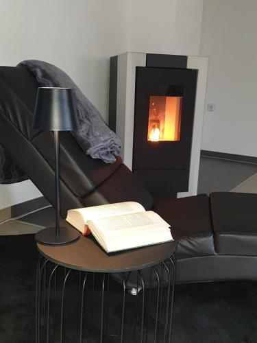 a living room with a couch and a table with a book at Ferienwohnung am Halfterweg in Hirschberg