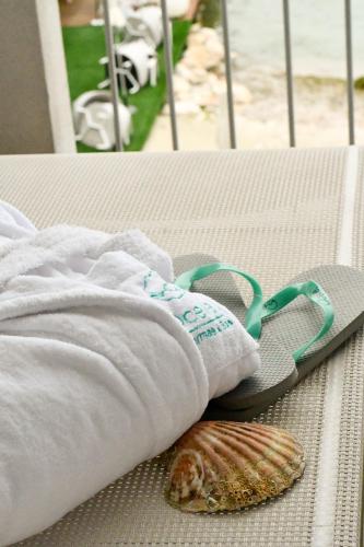 a pair of towels and a seashell on a table at Hotel Ocelle Thermae&Spa (Adults Only) in Sirmione
