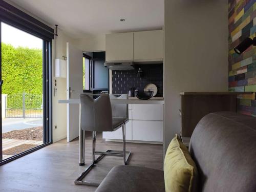 a bedroom with a bed and a kitchen with a table at Entre Vignes et Forêt in Tauxières-Mutry