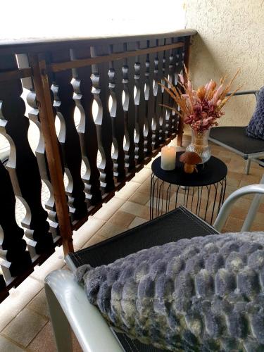 a balcony with a bench and a table with a vase of flowers at Ferienwohnung am Halfterweg in Hirschberg