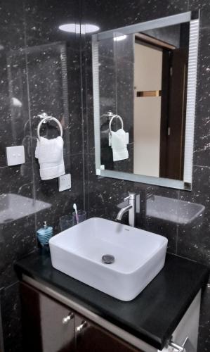 a bathroom with a white sink and a mirror at La grande Hotel & Residence in Angeles