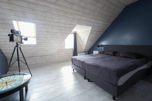 a bedroom with a bed and a camera on a tripod at Vakantiehuisje aan de Ijzer in Diksmuide