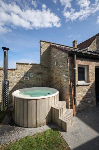 a hot tub in the backyard of a house at Vakantiehuisje aan de Ijzer in Diksmuide
