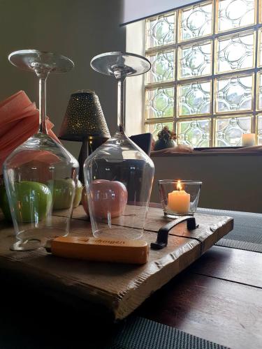 a table with two wine glasses and candles on it at Ferienwohnung am Halfterweg in Hirschberg