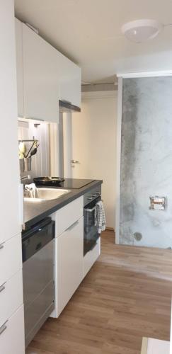 a white kitchen with a sink and a counter at Room with shared kitchen and bathroom nr 2 in Tromsø
