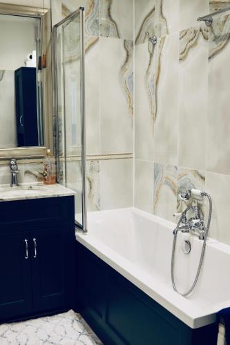 a bathroom with a shower and a tub and a sink at Flat in the heart of Bath with stunning views in Bath