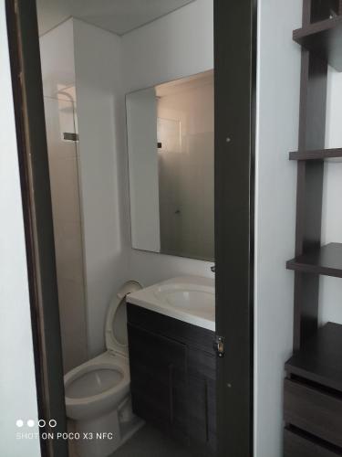 a bathroom with a sink and a toilet with a mirror at Apartamento de tres habitaciones in Rodadero