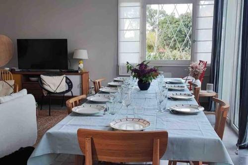 - une longue table avec des assiettes et des verres à vin dans l'établissement Villa Faustine Arcachon, à La Teste-de-Buch