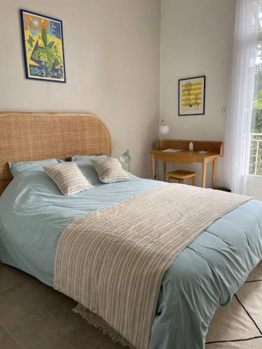 une chambre avec un grand lit avec des draps bleus dans l'établissement Villa Faustine Arcachon, à La Teste-de-Buch