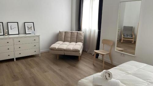 a bedroom with a bed and a chair and a dresser at Suites Larios Rooms in Málaga